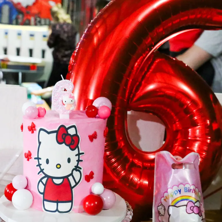 Sixth birthday party, a Hello Kitty themed cake with red foil number balloons