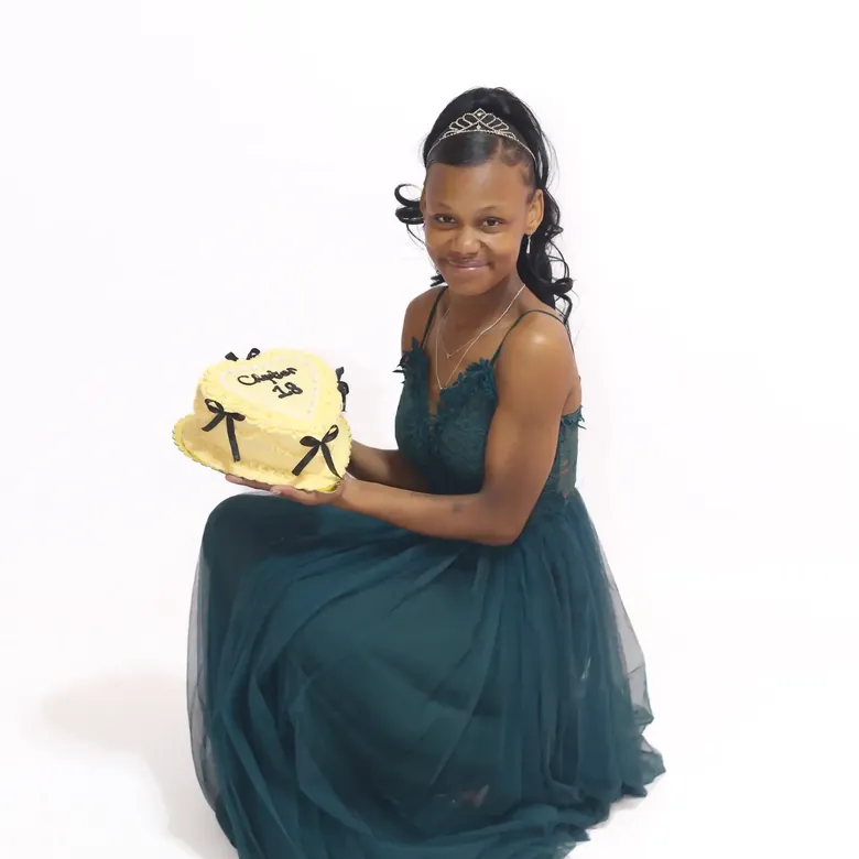 18th birthday session, a young woman in a teal tulle gown holding a Chapter 18 heart cake