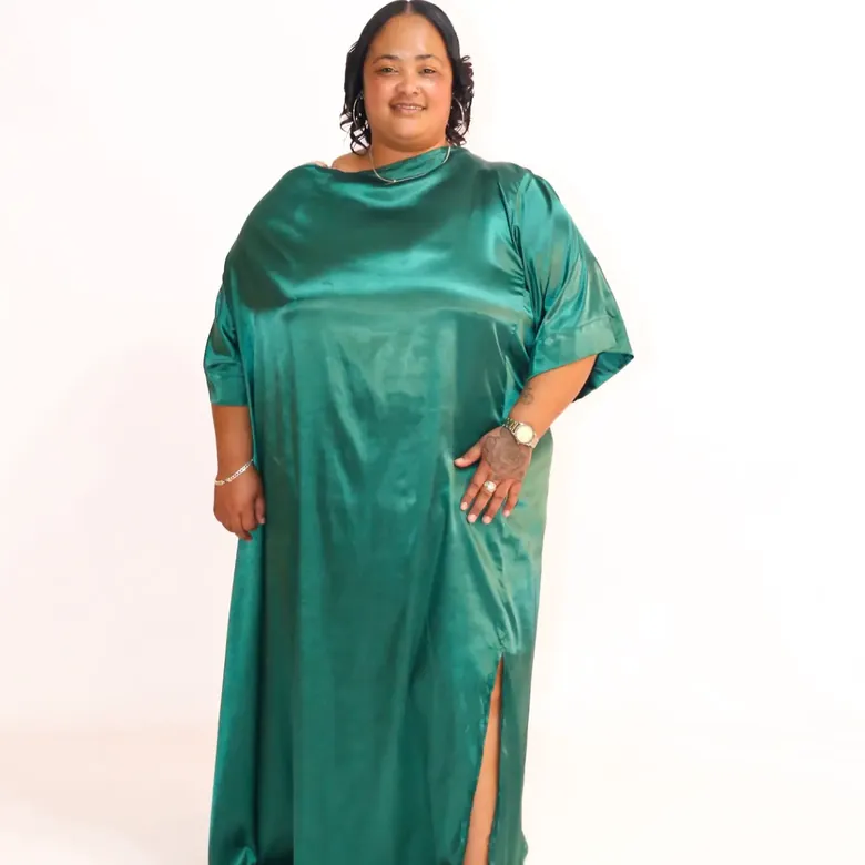 Milestone birthday session, client standing full-length in an emerald green satin gown